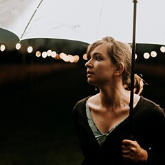 Woman under an umbrella looking thoughtful